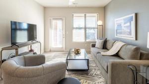 un soggiorno con divano e tavolo di Landing - Modern Apartment with Amazing Amenities (ID8251X95) a Wake Forest
