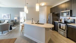 una cucina con lavandino e piano di lavoro di Landing - Modern Apartment with Amazing Amenities (ID8251X95) a Wake Forest