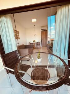 uma sala de estar com uma mesa de vidro e cadeiras em Flat Fazenda Monte Castelo Gravatá em Gravatá
