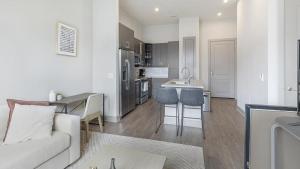 un soggiorno e una cucina con divano e tavolo di Landing - Modern Apartment with Amazing Amenities (ID5020X49) a Plano