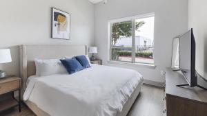 um quarto branco com uma cama e uma janela em Landing - Modern Apartment with Amazing Amenities (ID5020X49) em Plano