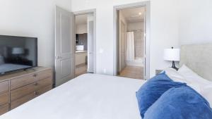 una camera bianca con letto e televisore di Landing - Modern Apartment with Amazing Amenities (ID5020X49) a Plano