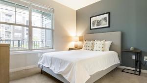 sypialnia z białym łóżkiem i oknem w obiekcie Landing - Modern Apartment with Amazing Amenities (ID2905X13) 