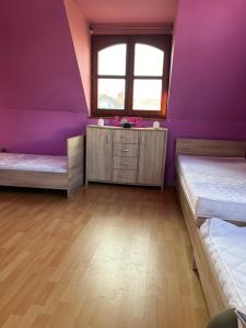 um quarto roxo com 2 camas e um lavatório em BRC Hostel & Car Rent Budapest em Budapeste