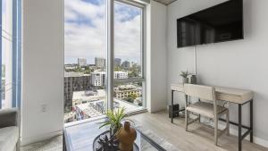 uma sala de estar com uma secretária e uma grande janela em Landing - Modern Apartment with Amazing Amenities (ID1187X358) em Portland