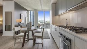 uma cozinha com uma mesa, cadeiras e um fogão em Landing - Modern Apartment with Amazing Amenities (ID1187X358) em Portland