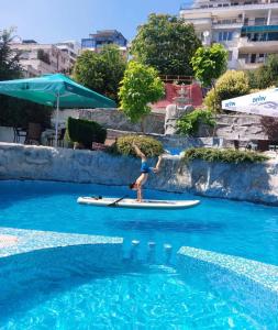 a person on a paddle board in the water at Brilliance Family Hotel in Varna City