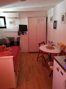 Habitación pequeña con sofá y mesa. en Guest House Accommodation Rupine, en Premantura