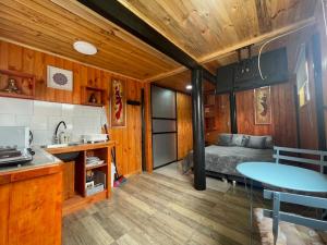 a kitchen with a table and a bed in a room at ELUNEY Pichilemu in Pichilemu