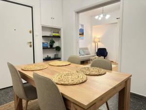 een houten tafel met stoelen en een eetkamer bij Superb New Family Apartment vipgreece in Athene