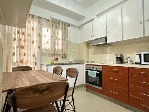 een keuken met een houten tafel en stoelen bij Superb New Family Apartment vipgreece in Athene