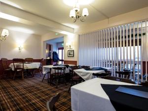 uma sala de jantar com mesas e cadeiras num restaurante em The Keyberry Hotel em Newton Abbot
