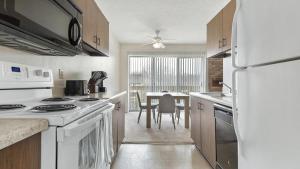 a kitchen with white appliances and a dining room at Landing - Modern Apartment with Amazing Amenities (ID9305X02) in Ballwin