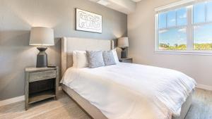 Landing - Modern Apartment with Amazing Amenities (ID8094X55) في Fort Myers Villas: غرفة نوم بسرير ابيض ونافذة