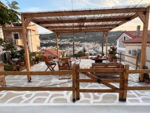 a wooden pergola on a patio with a view at Neoclassical Samos House Nafsika in Samos +16 photos