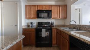 a kitchen with a black stove and a sink at Landing - Modern Apartment with Amazing Amenities (ID8086X70) in Scottsdale