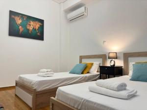 een kamer met 2 bedden en handdoeken erop bij Superb New Family Apartment vipgreece in Athene