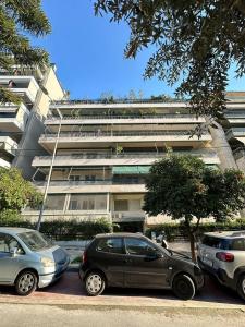 een parkeerplaats met auto's voor een gebouw bij Superb New Family Apartment vipgreece in Athene