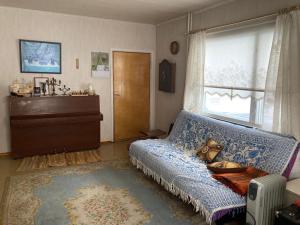 ein Wohnzimmer mit einem Sofa und einem Fenster in der Unterkunft Old Cozy Wood House in Rovaniemi