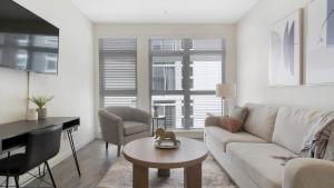 Sala de estar blanca con sofá y mesa en Landing - Modern Apartment with Amazing Amenities (ID8324X58), en Woodinville
