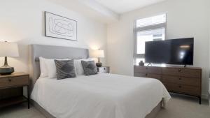 ウッディンビルにあるLanding - Modern Apartment with Amazing Amenities (ID8324X58)の白いベッドルーム(大型ベッド1台、薄型テレビ付)
