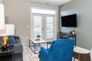 un soggiorno con sedia blu e divano di Landing - Modern Apartment with Amazing Amenities (ID4378) ad Auburn Hills