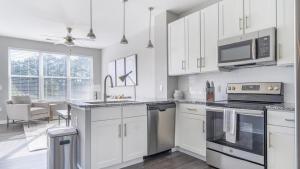 a kitchen with white cabinets and a stove top oven at Landing - Modern Apartment with Amazing Amenities (ID9798X32) in Chapel Hill