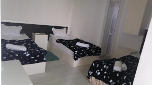 a small room with two beds with black and white sheets at Kai Hotel in Tbilisi City