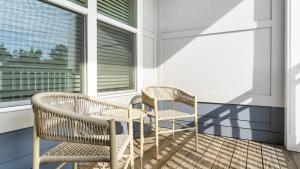two wicker chairs and a table on a balcony at Landing - Modern Apartment with Amazing Amenities (ID9798X32) in Chapel Hill