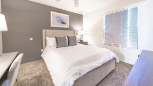 1 dormitorio con cama blanca y ventana en Landing - Modern Apartment with Amazing Amenities (ID7250X84) en Albuquerque