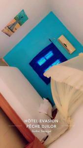 a room with a bed with a blue wall at Hotel evasion peche in Fimela