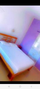 ein Schlafzimmer mit einem weißen Bett mit violetten Lichtern in der Unterkunft Hotel evasion peche in Fimela