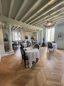 een eetkamer met tafels en stoelen en een kroonluchter bij Hôtel du Château du Bois-Guibert in Bonneval