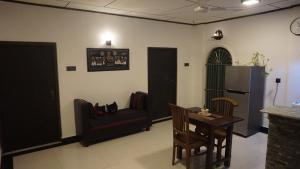 ein Wohnzimmer mit einem Tisch und einem Stuhl in der Unterkunft The Whitegates Lodge in Weligama