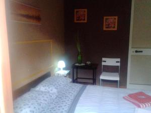 una camera da letto con un letto bianco e una luce sopra di Stanza 30 euro per 2 ore Acireale a Santa Tecla