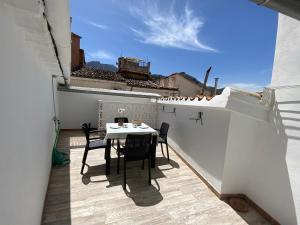 patio con mesa y sillas en el balcón en Casa La Romera, en Cazorla