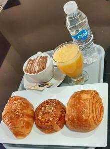 een dienblad met een bord gebak en een glas sinaasappelsap bij Hôtel Riad Salam Agadir in Agadir