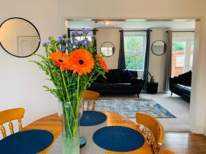 a vase of flowers on a table in a living room at Chic 5 Bedroom House with Private Parking & Garden in Bristol