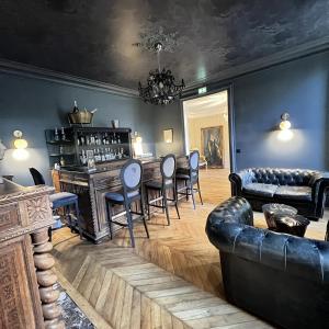 uma sala de estar com um bar com cadeiras e um sofá em Hôtel du Château du Bois-Guibert em Bonneval