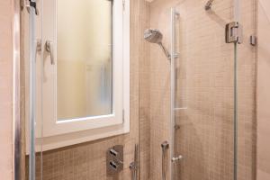 a shower with a glass door and a window at Smooth Mansion in Ponte Vecchio in Florence