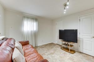 a living room with a couch and a flat screen tv at Pet-Friendly Birmingham Cottage with Private Hot Tub in Birmingham