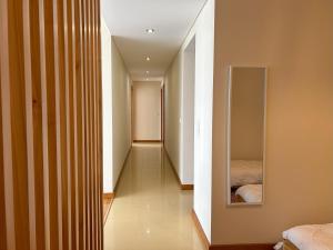 um corredor com uma cama e um espelho na parede em Oceanus Executive em Ponta Delgada