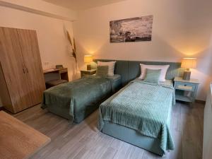 Habitación de hotel con 2 camas y sofá en HOLI DAY SPA 2-Bett Zimmer App 3, en Berlín