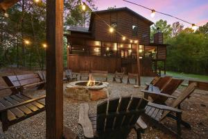 a fire pit in front of a log cabin at Iron Horse Lodge sleeps 18, Games, Fire Pit, Hot Tub, EV, more in Broken Bow
