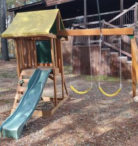 a playground with a slide and a play house at Iron Horse Lodge sleeps 18, Games, Fire Pit, Hot Tub, EV, more in Broken Bow +64 photos