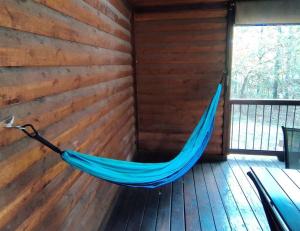 a hammock in a room with a wooden wall at Iron Horse Lodge sleeps 18, Games, Fire Pit, Hot Tub, EV, more in Broken Bow