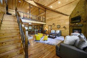 a living room with a staircase in a cabin at Iron Horse Lodge sleeps 18, Games, Fire Pit, Hot Tub, EV, more in Broken Bow