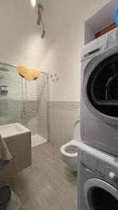 a bathroom with a toilet and a shower with a washing machine at Itiseasy Cuglieri Luxury Apartments in Cuglieri