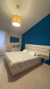a bedroom with a large bed with a blue wall at Itiseasy Cuglieri Luxury Apartments in Cuglieri