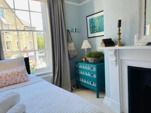 a bedroom with a bed and a fireplace and a window at Pass the Keys Cobblers Rest Luxury Elegance & Central Location in Bakewell